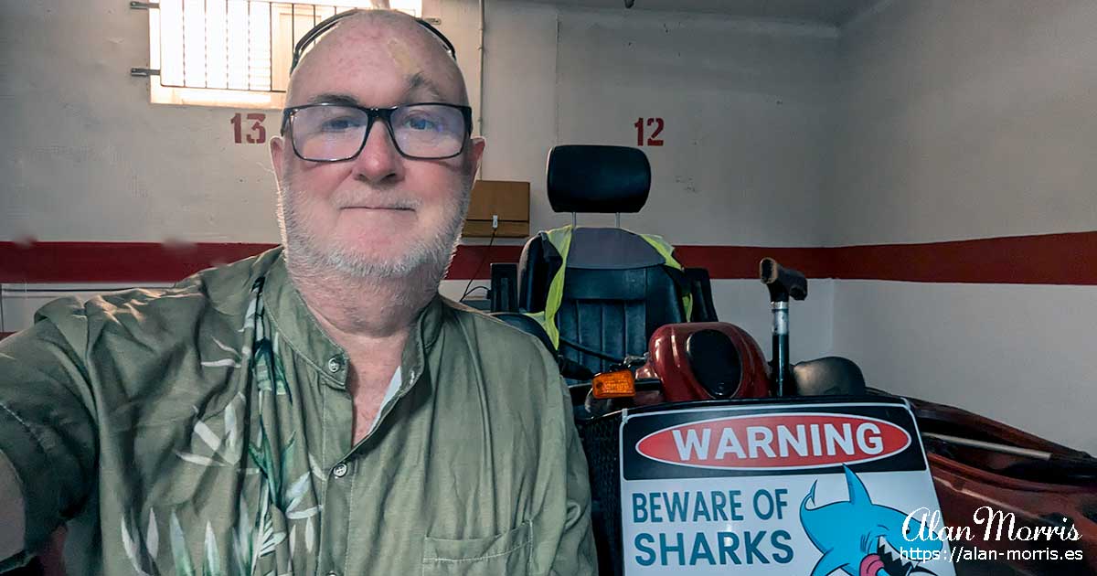 Alan Morris in his garage next to his disability scooter and kayak.